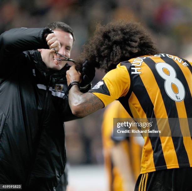 Tom Huddlestone of Hull city celebrates after scoring the team's 4th goal by having his hair cut after vowing to not have his hair cut until he...