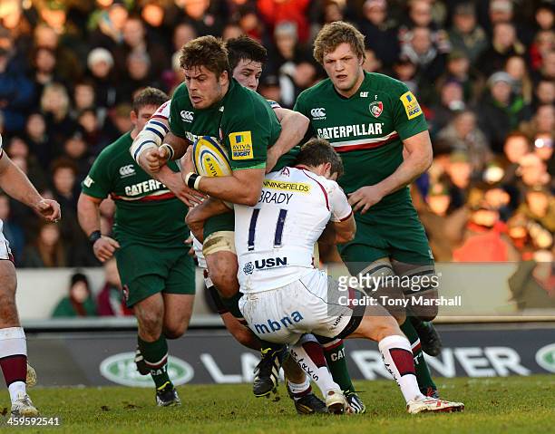 Ed Slater of Leicester Tigers tackled by Marc Jones and Tom Brady of Sale Sharks during the Aviva Premiership match between Leicester Tigers and Sale...