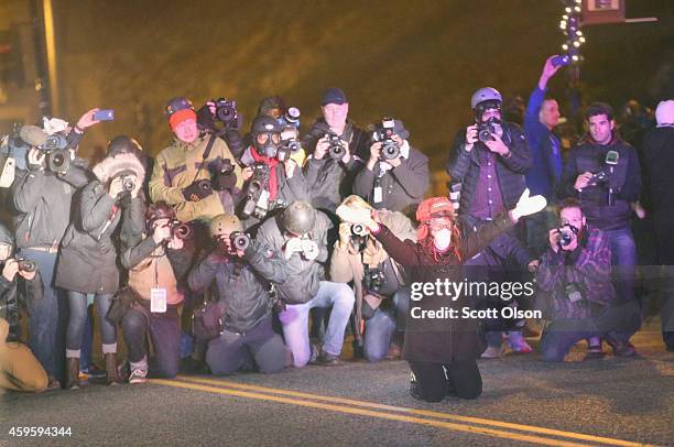 News photographers swarm a demonstrator as she prepares to be arrested during a protest on November 25, 2014 in Ferguson, Missouri. Yesterday...