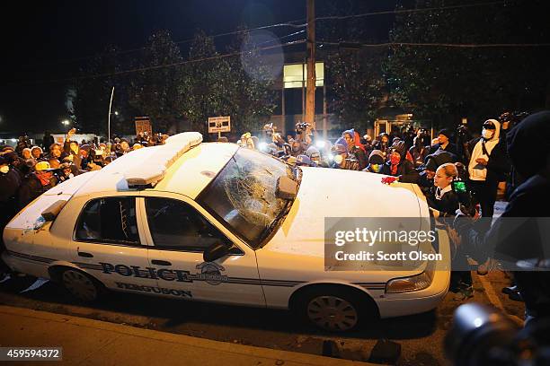 Police squad car is turned over by demonstrators during a protest on November 25, 2014 in Ferguson, Missouri. Yesterday protesting turned into...