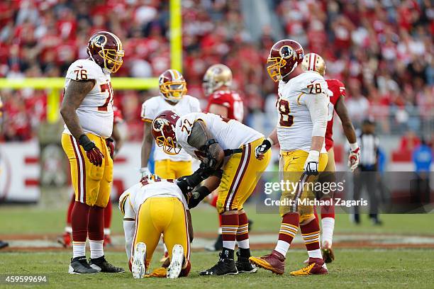 Shawn Lauvao of the Washington Redskins helps Robert Griffin III up after being knocked down during the game against the San Francisco 49ers at Levi...