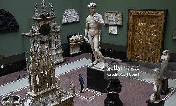 An employee poses next to a five metre high cast of Michelangelo's David during a press preview for the newly renovated Weston Cast Court at the...