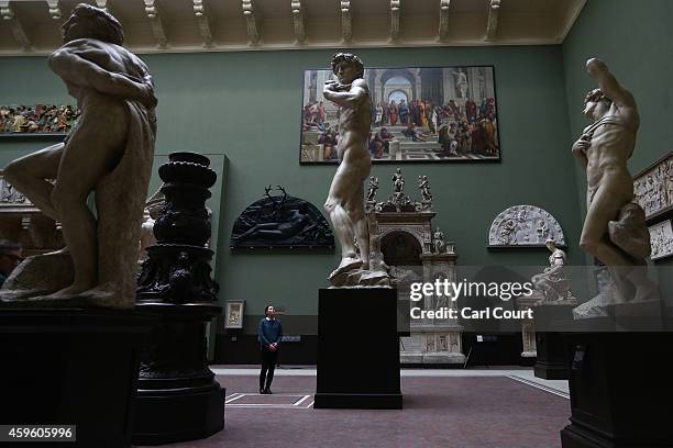 An employee poses next to a five metre high cast of Michelangelo's David during a press preview for the newly renovated Weston Cast Court at the...