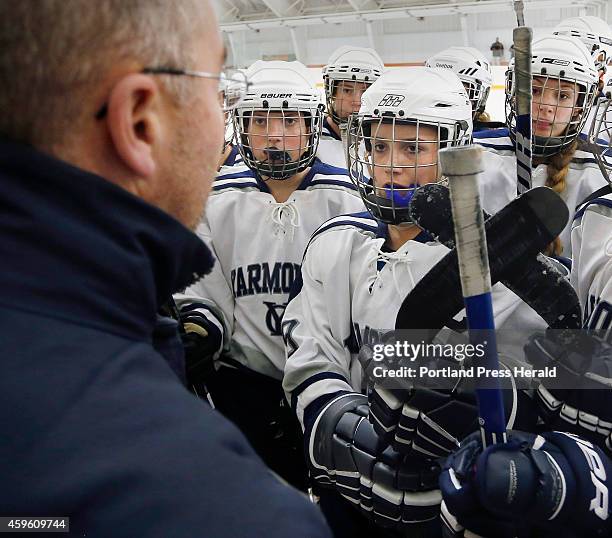 Michelle Robichaud, center, captain of the Yarmouth girls hockey team, listens to coach Jeff Haley with her teammates before a game against Brunswick...
