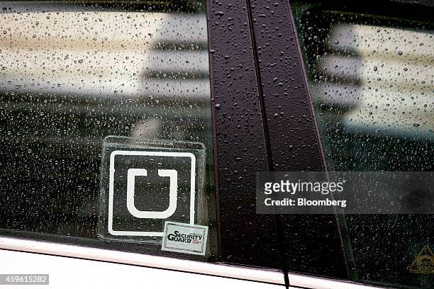 The Uber Technologies Inc. Logo is displayed on the window of a vehicle after dropping off a passenger at Ronald Reagan National Airport in...