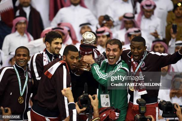 Qatar players carry the Gulf cup trophy after defeating Saudi Arabia 2-1 in the final of the 22nd Gulf Cup football match at the King Fahad stadium...