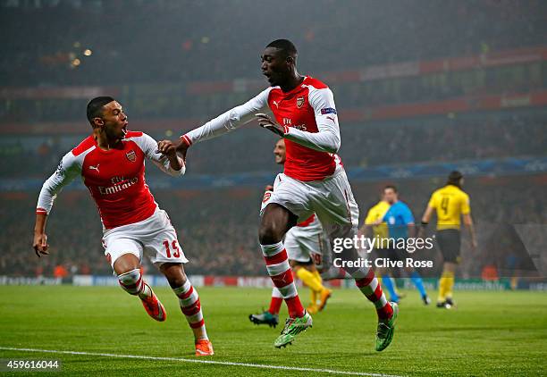 Yaya Sanogo of Arsenal celebrates with teammate Alex Oxlade-Chamberlain after scoring the opening goal during the UEFA Champions League Group D match...