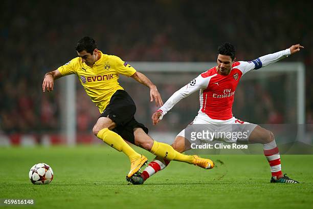 Henrikh Mkhitaryan of Borussia Dortmund is brought down by Mikel Arteta of Arsenal during the UEFA Champions League Group D match between Arsenal and...