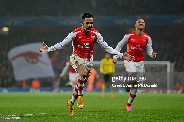 Alexis Sanchez of Arsenal celebrates with teammate Kieran Gibbs after scoring his team's second goal during the UEFA Champions League Group D match...