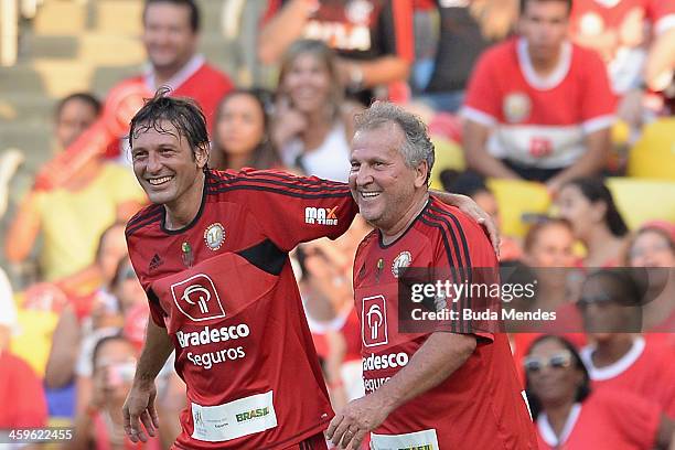 Brazilian former football star Zico celebrates a scored goal with a Leonardo during a charity football match organized by former Brazilian national...