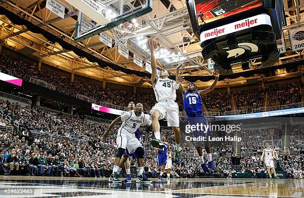 Denzel Valentine of the Michigan State Spartans drives the ball to the basket during the first half of the game as Kevin Hill of the New Orleans...