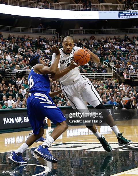 Adreian Payne of the Michigan State Spartans drives the ball to the basket as Kevin Hill of the New Orleans Privateers defends during the second half...