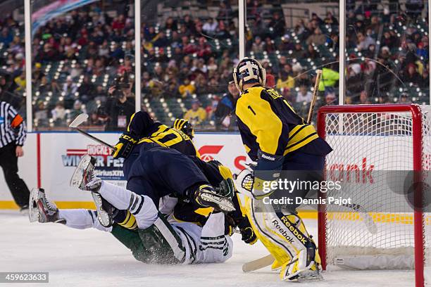 Zach Hymen of the Michigan Wolverines lays a massive hit on Lee Reimer of the Michigan State Spartans on December 28, 2013 at Comerica Park in...