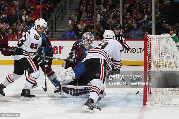 Jonathan Toews of the Chicago Blackhawks scores while teammate Kris Versteeg looks on against goaltender Calvin Pickard the Colorado Avalanche at the...