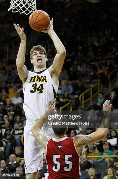 Center Adam Woodbury of the Iowa Hawkeyes goes to the basket against guard Michael Orris of the Northern Illinois Huskies, in the first half on...