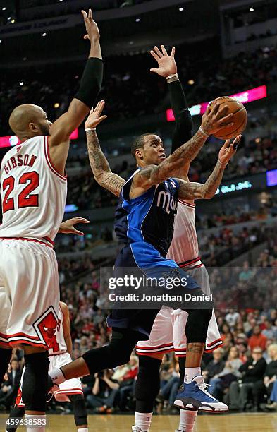 Monta Ellis of the Dallas Mavericks drives to the basket between Taj Gibson and Carlos Boozer of the Chicago Bulls at the United Center on December...