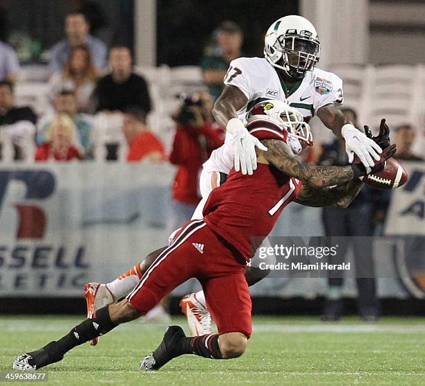 Miami's Ladarius Gunter, top, deflects a pass intended for Louisville's Damian Copeland in the first quarter of the Russell Athletic Bowl at the...