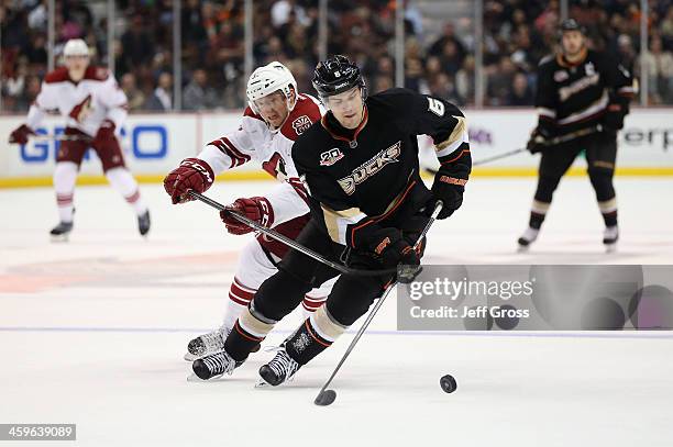 Ben Lovejoy of the Anaheim Ducks is pursued by Rob Klinkhammer of the Phoenix Coyotes for the puck in the second period at Honda Center on December...