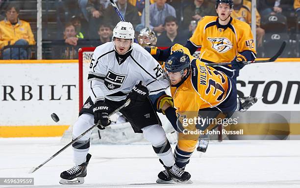 Slava Voynov of the Los Angeles Kings skates against Colin Wilson of the Nashville Predators at Bridgestone Arena on December 28, 2013 in Nashville,...