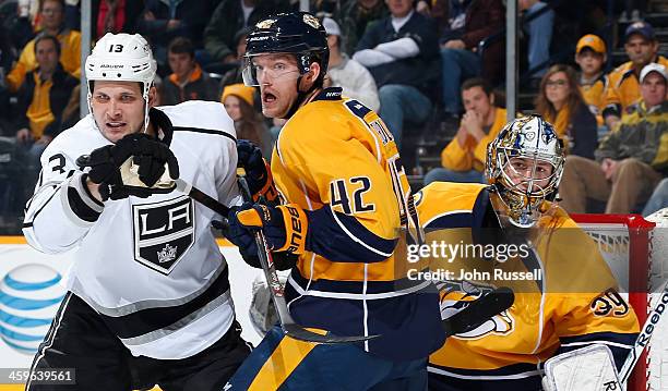 Kyle Clifford of the Los Angeles Kings battles against Mattias Ekholm and goalie Marek Mazanec of the Nashville Predators at Bridgestone Arena on...