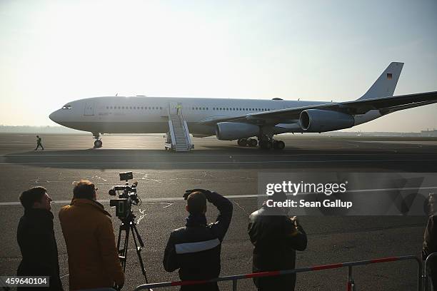 Journalists look on as a retrofitted Lufthansa plane equipped with medical isolation facilities for Ebola cases arrives during a media presentation...