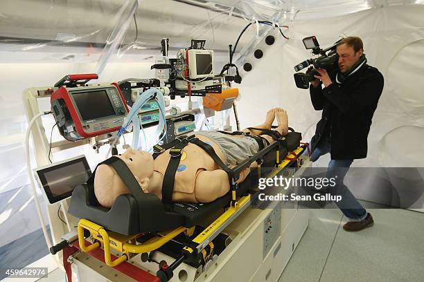 Member of the media films a mannequin lying in the isolation unit of a retrofitted Lufthansa plane equipped with medical facilities for Ebola cases...