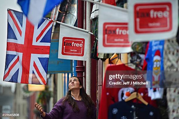 Woman hangs a Union Jack flag outside a tourist shop on the Royal Mile on November 27, 2014 in Edinburgh, Scotland. Lord Smith, announced that the...