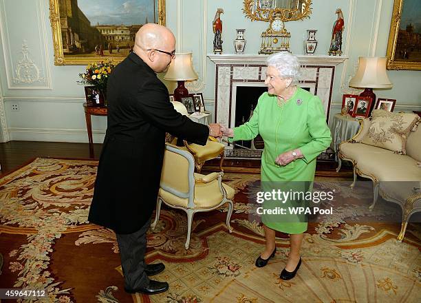 Queen Elizabeth II shakes hands with the newly appointed High Commissioner of Barbados, Mr Guy Hewitt, during a private audience at Buckingham Palace...