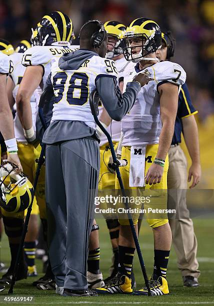 Quarterbacks Devin Gardner and Shane Morris of the Michigan Wolverines talk on the sideline during the Buffalo Wild Wings Bowl against the Kansas...