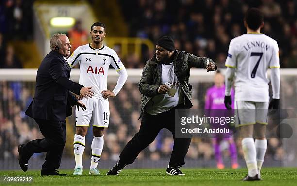 Pitch invader is chased by security as Kyle Naughton and Aaron Lennon of Tottenham Hotspur looks on during the UEFA Europa League group C football...