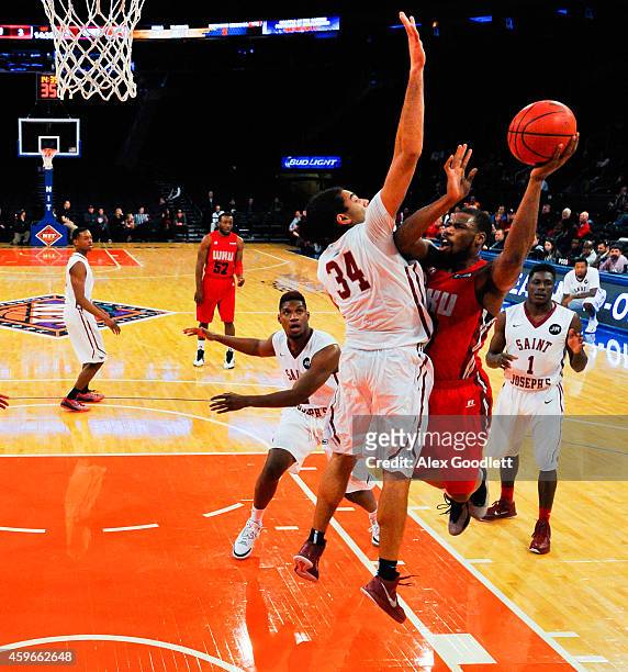 George Fant of the Western Kentucky Hilltoppers attempts a shot over Javon Baumann of the Saint Joseph's Hawks in the first half at Madison Square...