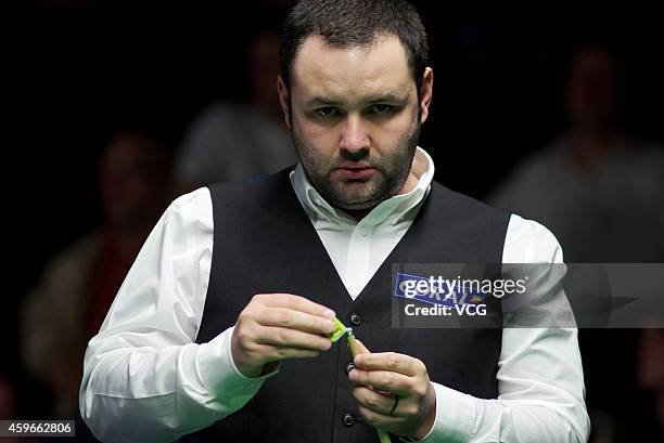 Stephen Maguire of Scotland chalks his cue against Lu Ning of China on day three of the 2014 Coral UK Championship at York Barbican on November 27,...