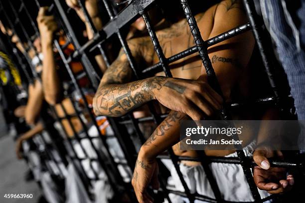 Mara Salvatrucha gang members are seen behind the bars of cells at a detention center on February 20, 2013 in San Salvador, El Salvador. Although the...