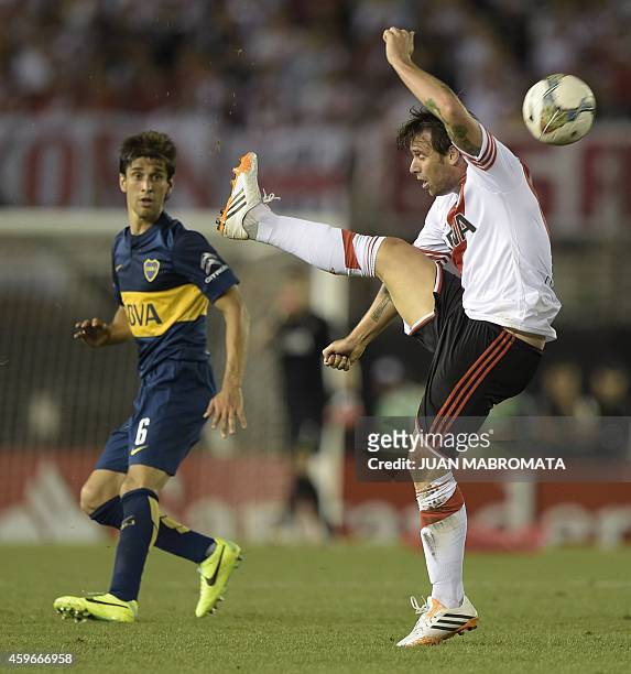 River Plate's forward Fernando Cavenaghi strikes the ball next to Boca Juniors' defender Juan Forlin during their Copa Sudamericana 2014 semifinals...