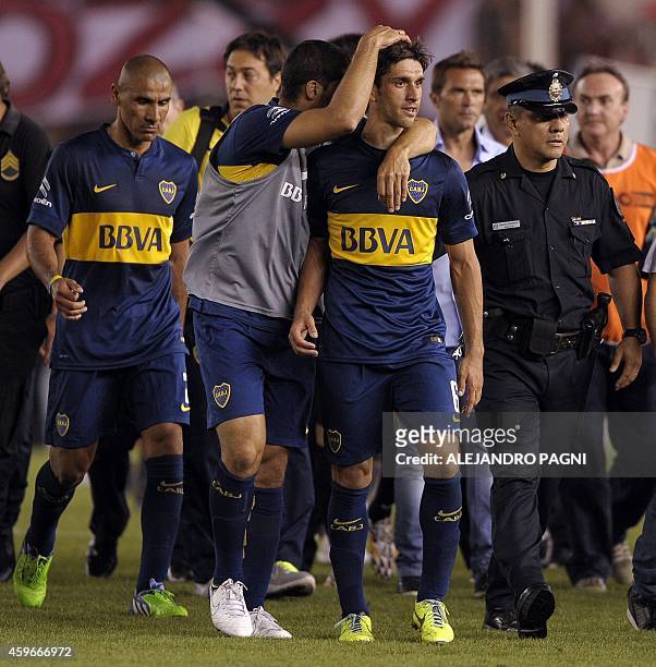 Boca Juniors' defenders Juan Forlin , Daniel Diaz and other players react while leave the field at the end of the Copa Sudamericana 2014 semifinal...
