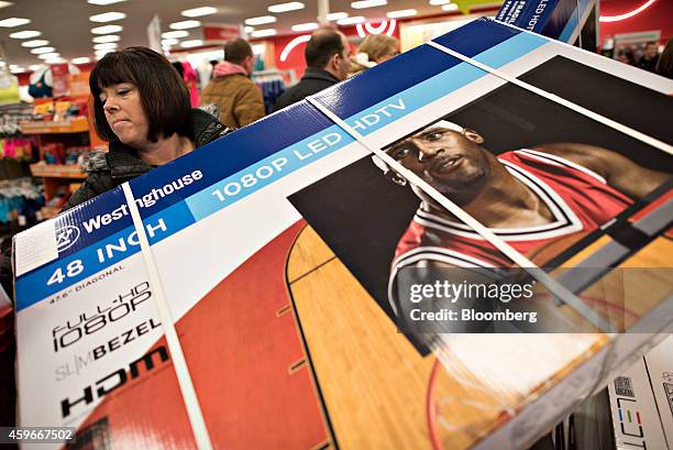 Shopper Wendy Hutton loads a 48-inch television into a shopping cart at a Target Corp. Store ahead of Black Friday in Mentor, Ohio, U.S., on...