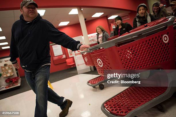 Customer takes hold of a shopping cart as he enters a Target Corp. Store ahead of Black Friday in Mentor, Ohio, U.S., on Thursday, Nov. 27, 2014. An...