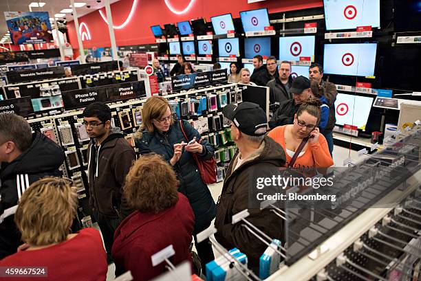 Shoppers wait in line to pay for items in the electronics department at a Target Corp. Store ahead of Black Friday in Mentor, Ohio, U.S., on...