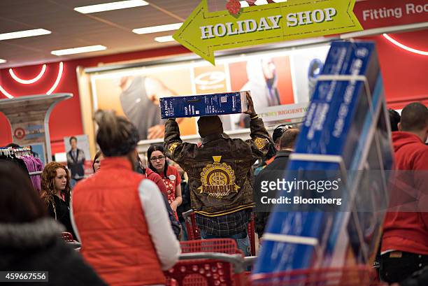 Shopper carries a flat screen television over his head at a Target Corp. Store ahead of Black Friday in Mentor, Ohio, U.S., on Thursday, Nov. 27,...