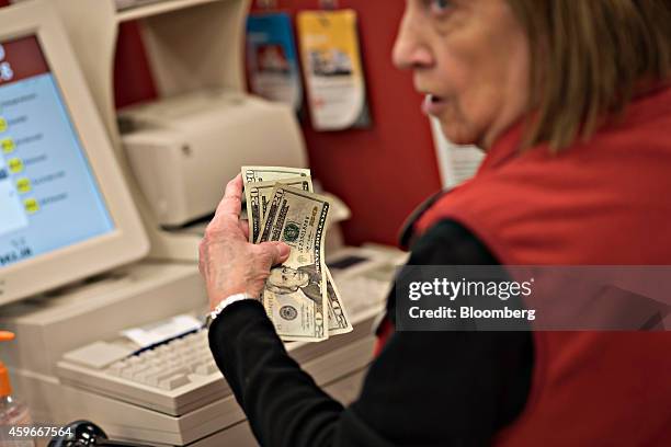 Cashier holds a customers cash during a transaction at a Target Corp. Store ahead of Black Friday in Mentor, Ohio, U.S., on Thursday, Nov. 27, 2014....
