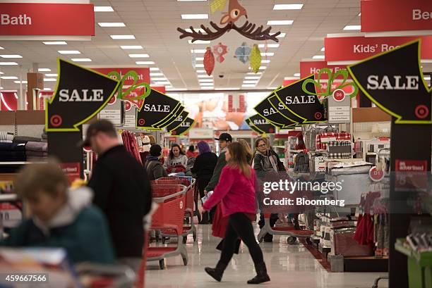Sale signs hang above shoppers at a Target Corp. Store ahead of Black Friday in Mentor, Ohio, U.S., on Thursday, Nov. 27, 2014. An estimated 140...