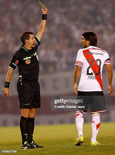 Referee German Delfino issues a yellow card to Leonardo Ponzio, of River Plate, during a second leg semifinal match between River Plate and Boca...