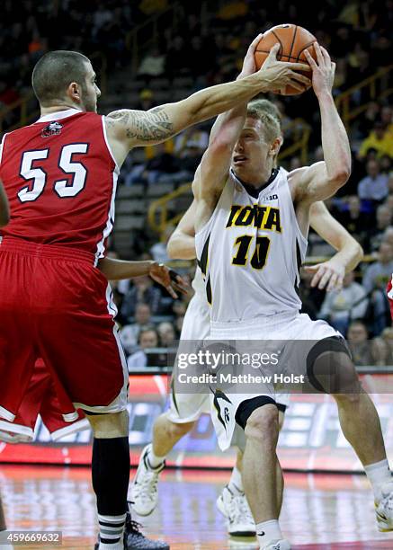 Guard Mike Gesell of the Iowa Hawkeyes brings the ball down the court against guard Michael Orris of the Northern Illinois Huskies, in the first half...