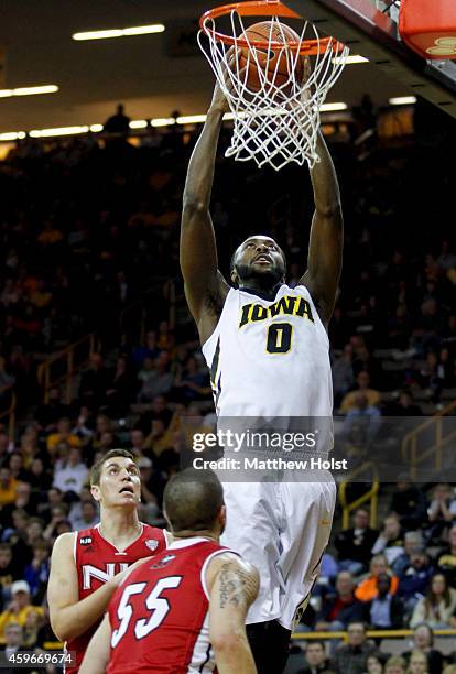 Center Gabriel Olaseni of the Iowa Hawkeyes dunks the ball overtop guard Michael Orris and center Marin Maric of the Northern Illinois Huskies, in...