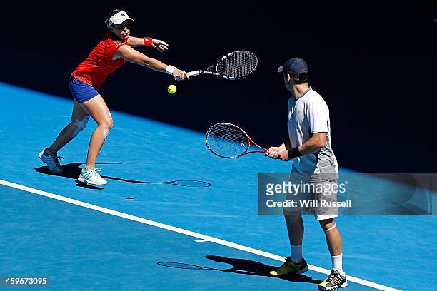 Anabel Medina Garrigues of Spain plays a backhand as Daniel Munoz-De La Nava looks on in the mixed doubles match against Petra Kvitova and Radek...