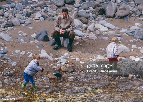 Charles, Prince of Wales, Prince William, and Prince Harry play on the bank of the River Dee, near Balmoral Estate, Scotland, on April 10 in...