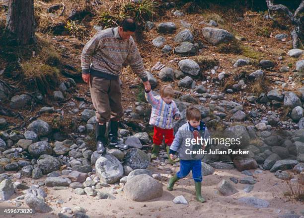 Charles, Prince of Wales, Prince William, and Prince Harry play on the bank of the River Dee, near Balmoral Estate, Scotland, on April 10 in...