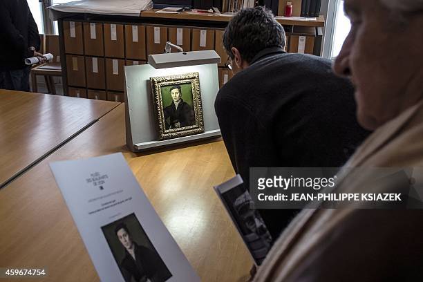 People look at a painting by France's Corneille "Homme au beret noir tenant une paire de gants" displayed on November 27, 2014 at the Musee des Beaux...