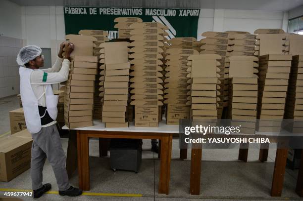 Workers counts boxes for condoms made with native latex at the Natex factory that produces around 100 million condoms per year for the Brazilian...