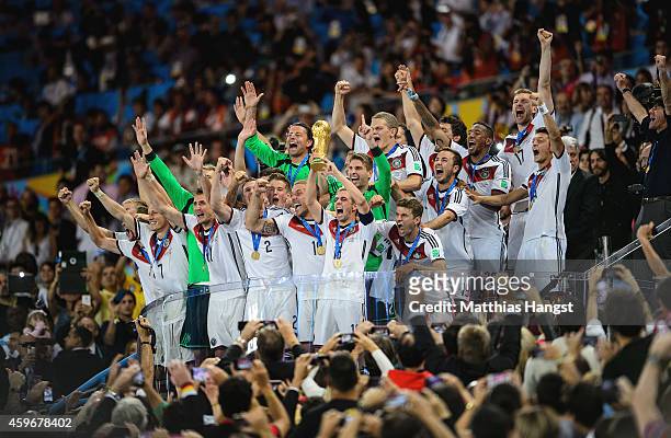 Philipp Lahm of Germany lifts the World Cup trophy with teammates after defeating Argentina 1-0 in extra time during the 2014 FIFA World Cup Brazil...